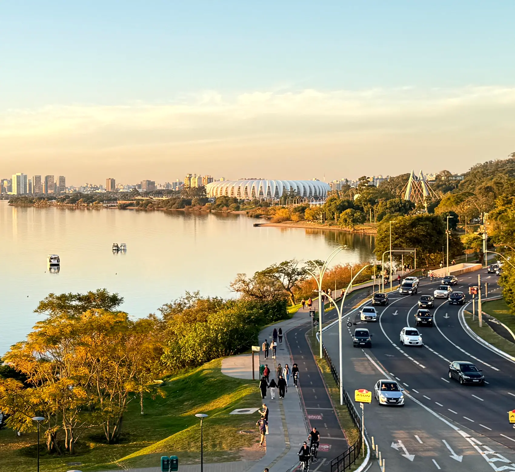 Orla do Guaíba em Porto Alegre ao entardecer, com o skyline da cidade ao fundo